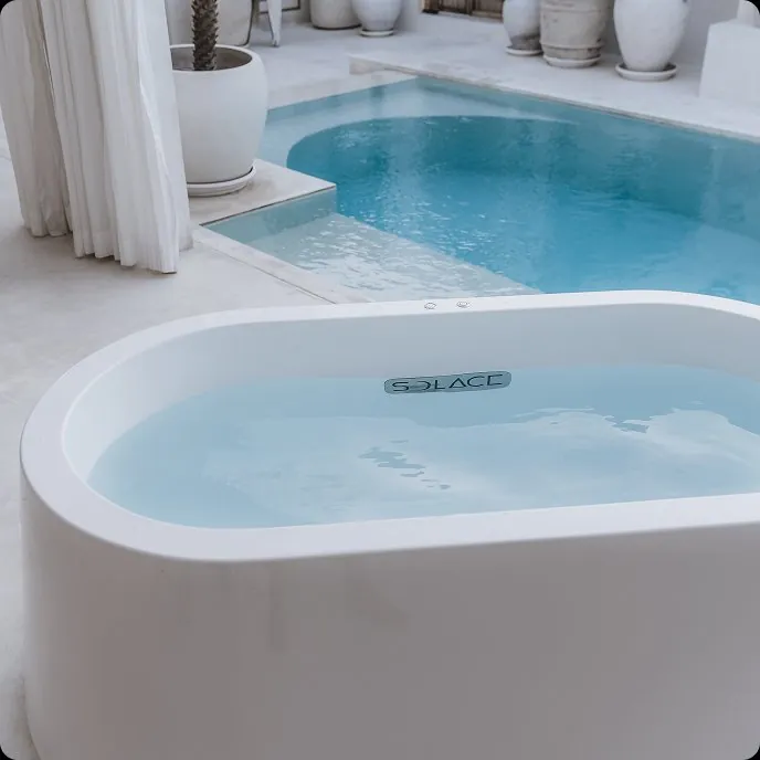 Solace ice bath positioned next to a swimming pool in a daytime residential setting