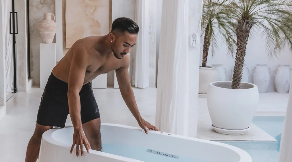 Man stepping into a Solace ice bath at a residential Bali villa, daytime wide crop